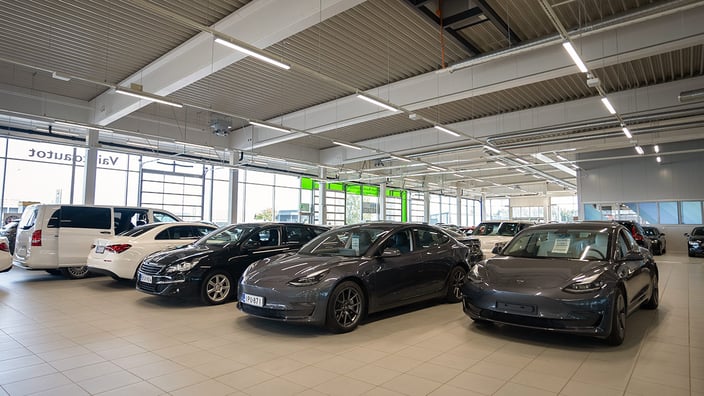 Autoliikkeen näyttelytila ja autoja rivissä