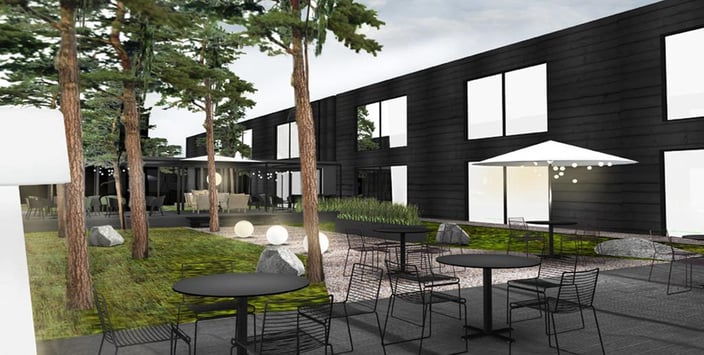 Havainnekuva tummasta hotellirakennuksesta ja sen terassista