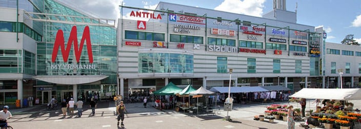 Kauppakeskus Myyrmannin julkisivu ja torimyyjiä sen edessä