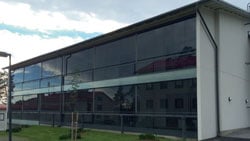 Lasijulkisivuinen rakennus ulkoa kuvattuna