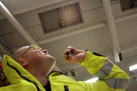 Asentaja tarkastaa savunpoistolaitteistoa katossa